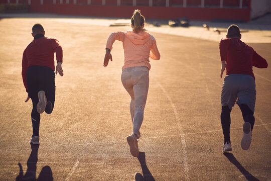  two men and one woman  racing at the athlete track