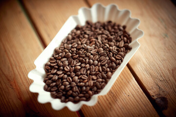 Close-up of roasted coffee beans in container on the table. Coffee, beverage, producing