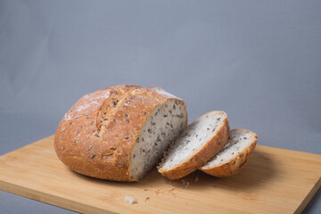 cut loaf of bread on cutting board against gray background