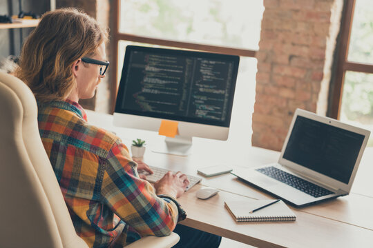 Profile side photo of young man work online computer monitor it specialist website coding sit desk indoors