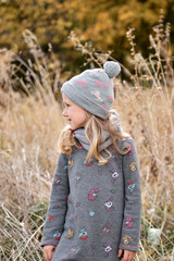 Girl having fun in dry reeds field. Autumn family walk in forest