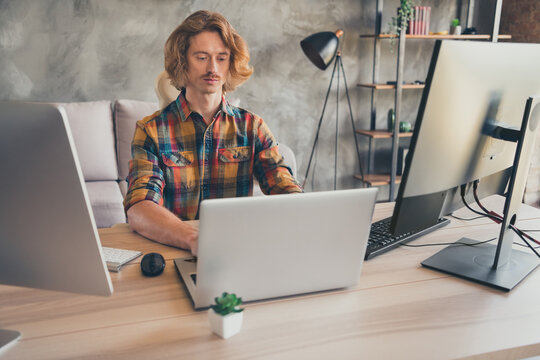 Photo of young guy it specialist programmer look laptop work jawascript internet online sit desk worker indoors - Powered by Adobe