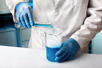 Scientist working with tubes for mixing fluids in the chemistry lab. Researcher in Research laboratory working for development of experiments with liquids