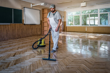 worker vacuuming the dust of the floor