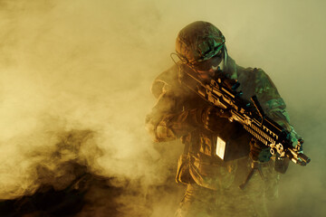 Portrait of airsoft player in professional equipment with machine gun in abandoned ruined building. Soldier with weapons at war in smoke and fog - obrazy, fototapety, plakaty