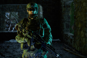 Portrait of airsoft player in professional equipment with machine gun in abandoned ruined building. Soldier with weapons at war