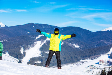 man on the top of the hill with snowboard in sunny day