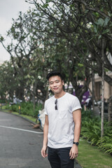 Portrait of asian young handsome man in casual clothing standing on the street and smiling. Asia, Chinese people, real life concept, sunny day