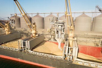 Loading grain into holds of sea cargo vessel through an automatic line in seaport from silos of...