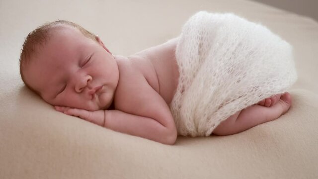 Photographing a newborn sleeping baby in a photo studio. Professional photography of a child in the studio, behind the scenes.