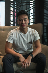 Fototapeta na wymiar Portrait of asian young handsome man in white t-shirt sitting in coffee shop and smiling. Lovely smile, Happy person, millennials life, lifestyle