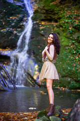 a beautiful woman sitting by a waterfall in different positions.