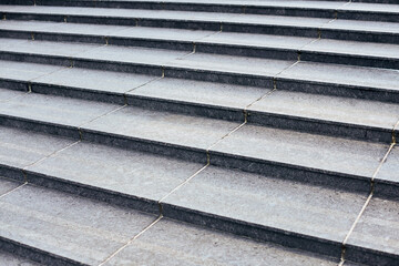 Grey stone steps in modern style, large staircase with stone-like grey texture, wide granite ladder