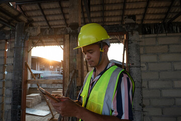Foreman inspecture new house building holding tablet computeer for record data