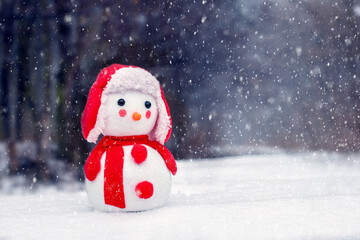 Snowman in the winter forest during a snowfall. Greeting Christmas and New Year card with snowmen