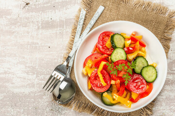 Seasonal fresh vegetable salad with ripe tomatoes, cucumbers, bell peppers