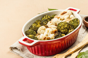 Baked broccoli and cauliflower on light beige background