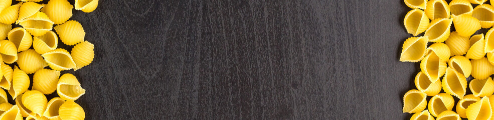 banner of Frame of A pile of conchiglie paste shells on black background with copyspace