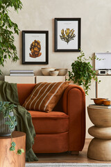 Creative interior composition of living room with designed couch, two mock up poster frames, coffee table, palnts, books and personal accessoriers. Template.