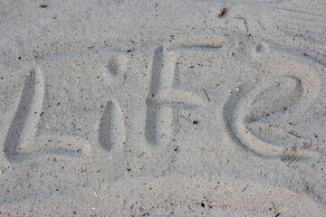 The inscription Life on the beach sand. the inscription on the beach.texture of beach sand by the sea