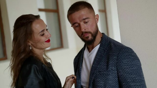 sensual woman is seducing emotionless man, embracing him and kissing