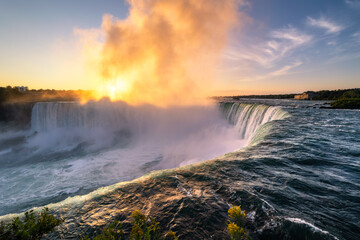 Vibrant sunrise illuminating the mist over Niagara Falls, Ontario Canada. 