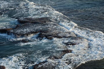 Sea Waves Crashing on the Rocks with White Foam. Swirling frothy foamy sea water over the rock near Akko(Acre) Israel