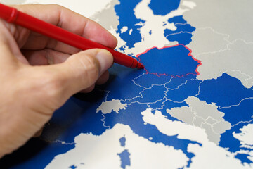 Hand drawing a red line between Poland and the rest of EU, Polexit concept.
