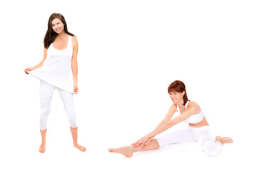 Fototapeta na wymiar Portraits of two slim young women wearing white leggings and tops in the gym, isolated on white background