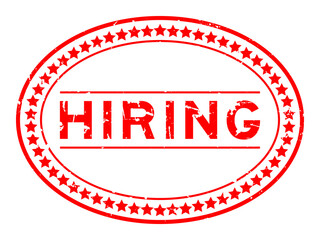 Grunge red hiring word oval rubber seal stamp on white background