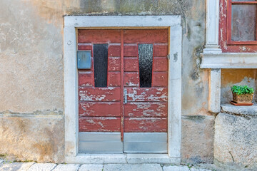 Picture of an old door in need of renovation with peeling red paint