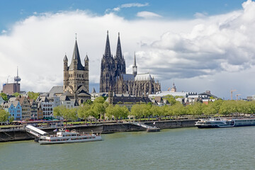 Towers of Cologne cathedral, and great saint Martin church and medieval houses on the embankment of river Rhine, Cologne, Germany