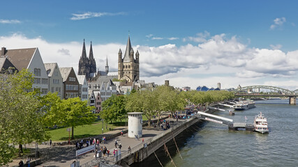 Fototapeta premium Quay along river Rhine with towers of the Cathedral and great Saint martin church and medieval houses in Cologne