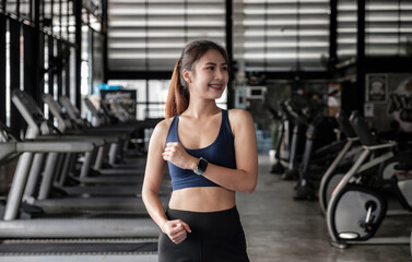 Fototapeta na wymiar Portrait of confident beautiful asian fitness woman standing after exercise in gym. Concept of slim and healthy happy girl workout