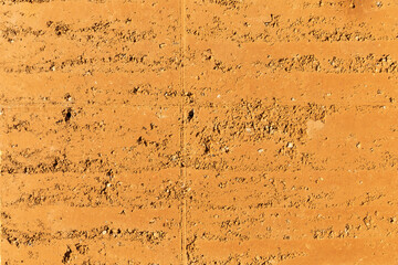 Rammed earth, an old building technique used to create the walls of a house by pressing sand into blocks. Sustainable and ecological textured material to build with. Future concept for housing - obrazy, fototapety, plakaty