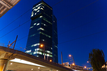 Fototapeta na wymiar Office tower Prime Tower at industrial district of City of Zürich on a beautiful autumn night with tram and bus station in the foreground. Photo taken October 9th, 2021, Zurich, Switzerland.