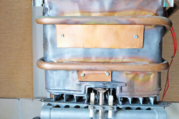 patches of copper on a burnt-out gas water heater heat exchanger