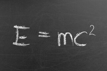Relativity equation E mc2 handwritten by chalk on a university blackboard. Science and education concepts and backgrounds - obrazy, fototapety, plakaty