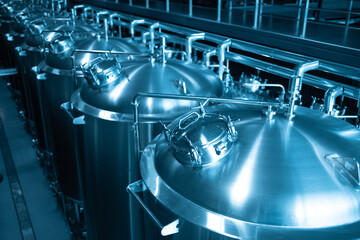 Private microbrewery. Modern beer plant with brewering kettles, tubes and tanks made of stainless...
