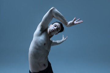 Half-length portrait of young man, flexible male contemp dancer dancing isolated on old navy studio background. Art, motion, inspiration concept.