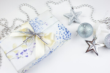 Very nice festive decor. Christmas gift box with festive decor in silver tones. Close-up, top view.
