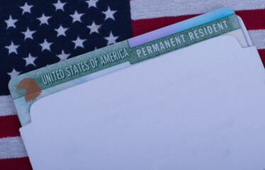 Green card or USA Permanent resident card on Flag of United States of America background. Free copy...