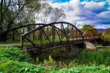 Fototapeta na wymiar old bridge, road to the past, history, autumn bridge against a background of blue clouds 