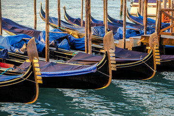 Fototapeta na wymiar Gondolas on the jetty of San Marco square in Venice at sunset
