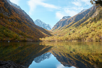 Fototapeta na wymiar Lake in the mountains, autumn mountain landscape, forest and mountain slopes in autumn colors, water and tranquility