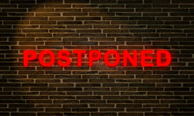Postponed in neon red glowing letters in front of a brownish brick wall. 3D illustration