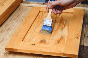 Painting a wooden surface with a brush