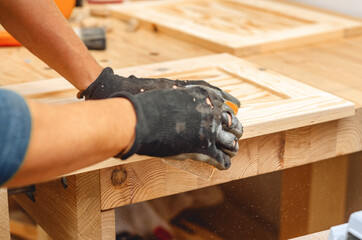 Manual sanding of wooden products. Hands of the master