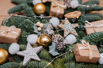 Fir branches with christmas decorations and gifts on kraft paper background
