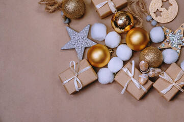 golden balls and other christmas decorations and gifts on kraft paper background
